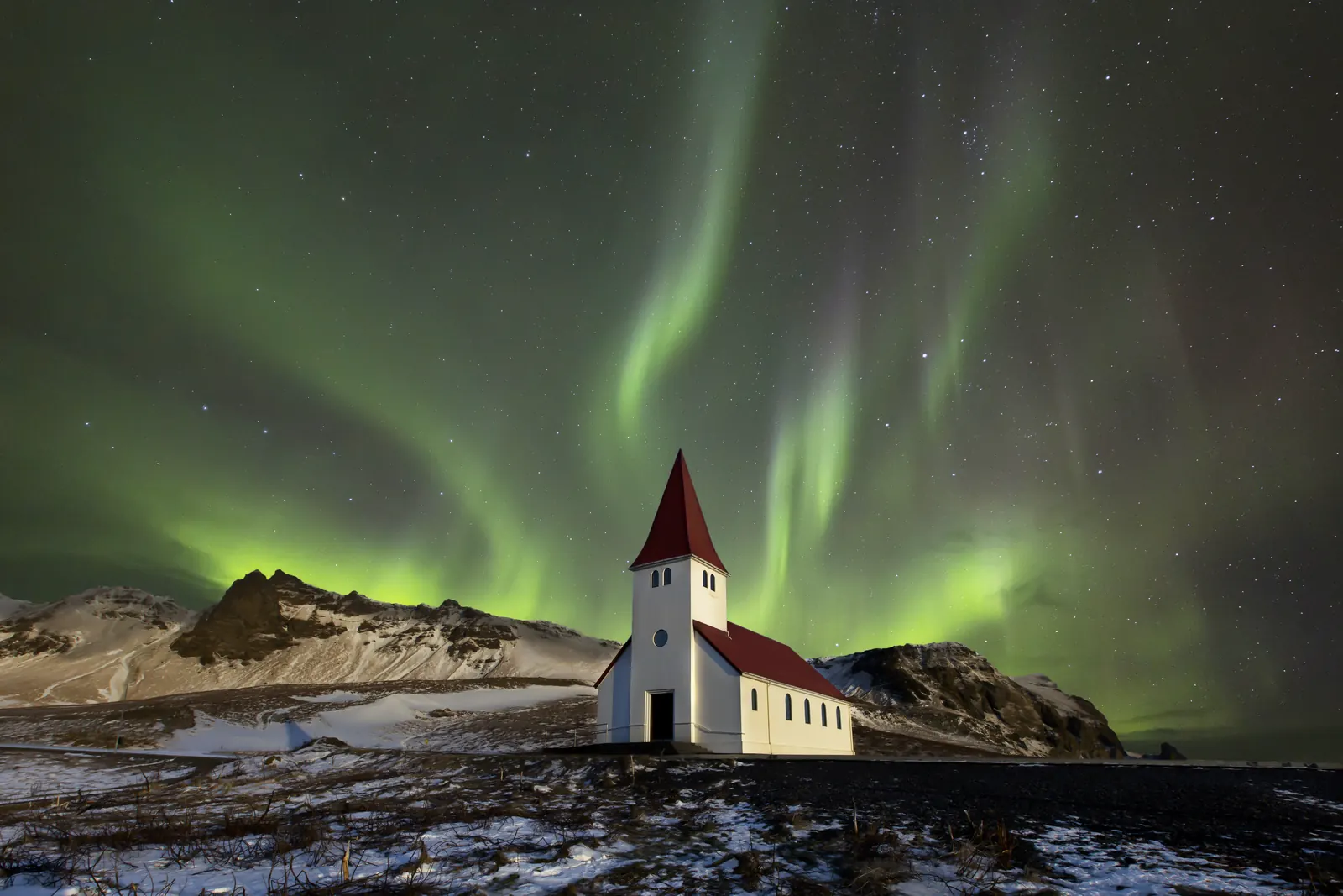 Aurora boreal sobre uma igreja na Islândia